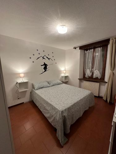 バルドネッキアにあるAppartamento Bardonecchiaのベッドルーム1室(ベッド1台、ランプ2つ、窓付)