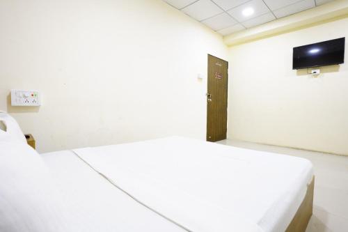 Habitación hospitalaria con 2 camas y TV en Hotel Silver, en Surat