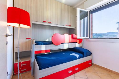 a small bedroom with two bunk beds and a red lamp at Appartamento L'Approdo Trilo Rosso - MyHo Casa in Marina di Montenero