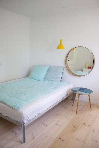 a bedroom with a bed with a mirror and a stool at House in beautiful Copenhagen in Copenhagen