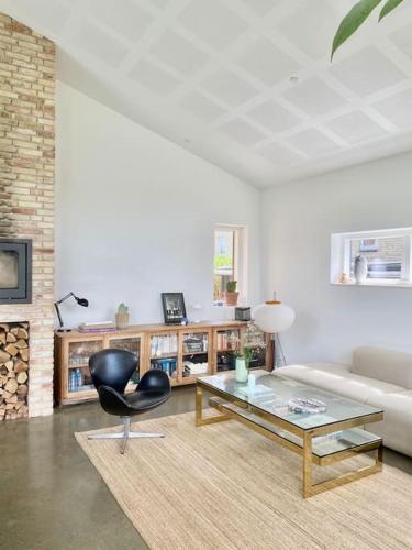 a living room with a black chair and a table at House in beautiful Copenhagen in Copenhagen