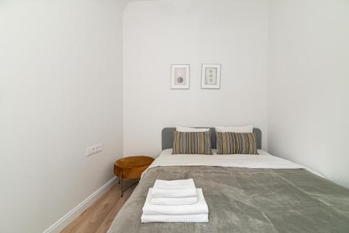 a white bedroom with a large bed with two pillows at New & Stylish Old Town Apartment by URBAN RENT in Vilnius