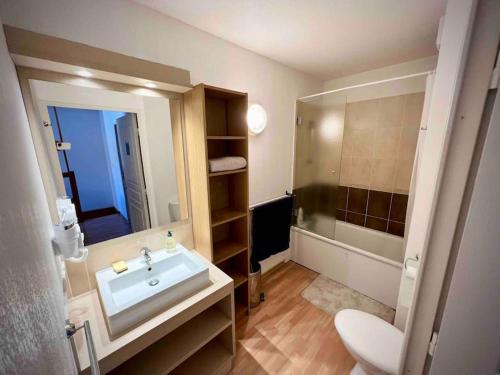 une salle de bain avec un lavabo et un miroir dans l'établissement Sous les toits des Orres, aux Orres