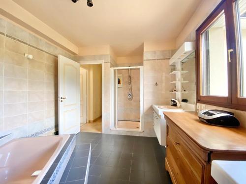 un ampio bagno con vasca e lavandino di LA KERVAO - Villa 5 chambres - Jardin - Terrasse - Internet a Quimper