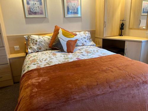 Un dormitorio con una cama con almohadas. en Coastal Caravan Holidays - Puffin 14, en Tunstall