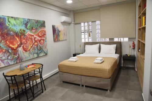 1 dormitorio con 1 cama, 1 mesa y 1 pintura en Ianos Β Panormou by SuperHost Hub en Atenas