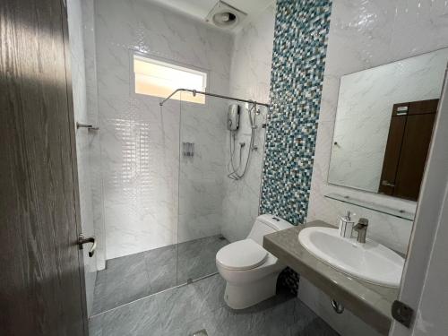 a bathroom with a toilet and a sink and a shower at River Grand Hotel in Hat Yai