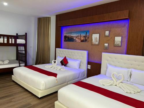 a bedroom with two beds and a bunk bed at River Grand Hotel in Hat Yai