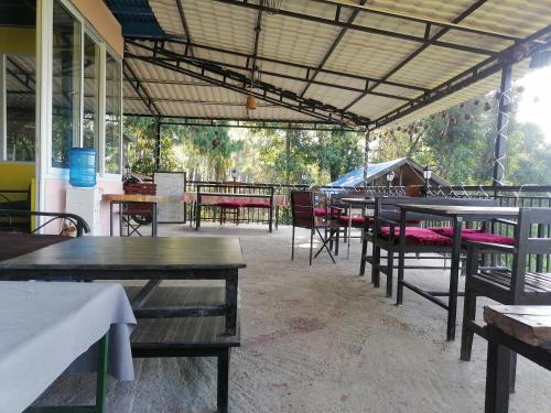 a group of tables and chairs in a restaurant at Jungle Crown Organic Homestay in Nagarkot