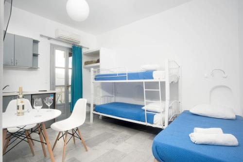 a bedroom with two bunk beds and a table and chairs at Depis apartments & suites in Naxos Chora