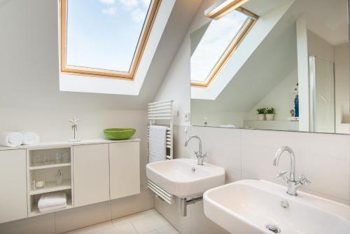 La salle de bains blanche est pourvue d'un lavabo et d'une fenêtre. dans l'établissement Ostsee - Appartement Nr 91 "Panta Rhei" im Strand Resort, à Heiligenhafen