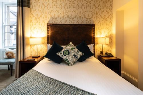 a bedroom with a large bed with two lamps at Bank House Pitlochry in Pitlochry