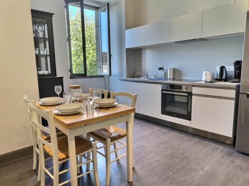 une cuisine avec une table en bois, des chaises, une table et une table dans l'établissement Le Coté Jardin - Fibre - Clim - Centre-ville, à Albi
