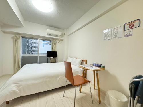a bedroom with a bed and a table with a chair at A&C STAY Shin-Osaka Higashikuchi 83 in Osaka
