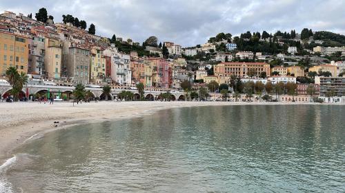 une plage en face d'une ville avec des bâtiments dans l'établissement TreG5, à Menton
