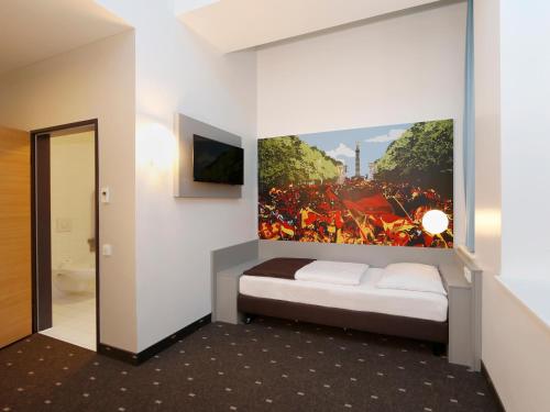 una camera da letto con un letto e un dipinto sul muro di B&B Hotel Berlin-Tiergarten a Berlino