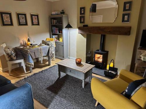 a living room with a table and a fireplace at Victoria Cottage in Barnard Castle