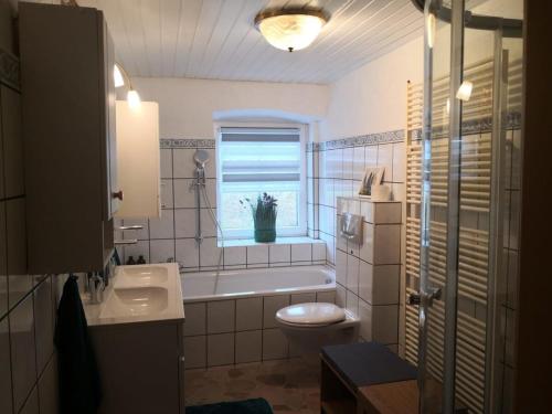 a bathroom with a tub and a toilet and a window at Landhaus Ferien Sommer in Bleckede