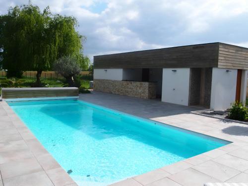 une piscine devant une maison dans l'établissement L'Ecolière - Villa Piscine Chauffée - Rêve au Mans, à Teillé