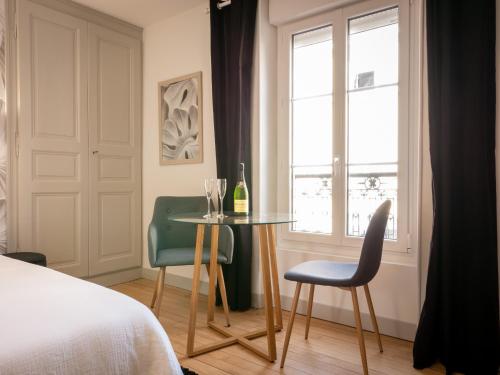 sypialnia ze stołem, 2 krzesłami i oknem w obiekcie Le Night Dream - Sauna - Gare - Palais des Congrès - Rêve au Mans w mieście Le Mans