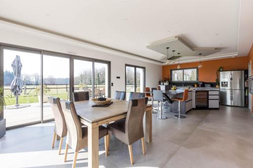 une cuisine et une salle à manger avec une table et des chaises dans l'établissement Le Yucca Spa -Campagne-Jacuzzi- 8p - Rêve au Mans, à La Grenouillère