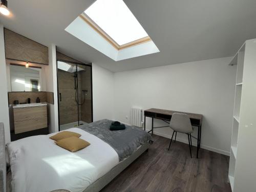 sypialnia z łóżkiem, biurkiem i oknem dachowym w obiekcie Le Galant - Centre - Spacieux - 18p - Rêve au Mans w mieście Le Mans