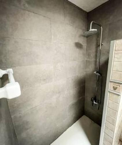 a bathroom with a shower with a toilet paper dispenser at Beachfront Villa San Antonio with Private Heated Pool BBQ in the Heart of Corralejo by Amazzzing Travel in Corralejo