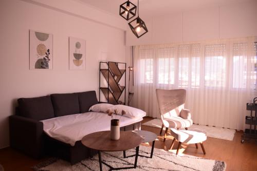 sala de estar con sofá, mesa y sillas en Antonia's city apartment en Ioánina