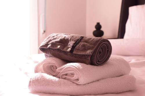 una pila de toallas sentadas encima de una cama en Antonia's city apartment en Ioánina