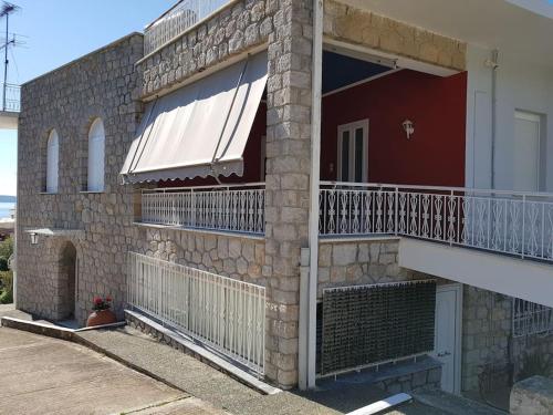 um edifício de tijolos com uma varanda e um alpendre em Villa Elea em Tolo