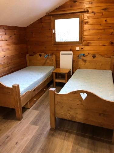 a room with two beds in a wooden cabin at Chalet Flocon in Les Deux Alpes