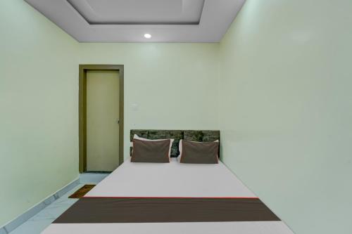 een slaapkamer met een wit bed met 2 kussens bij Collection O Hotel Park City in Patna