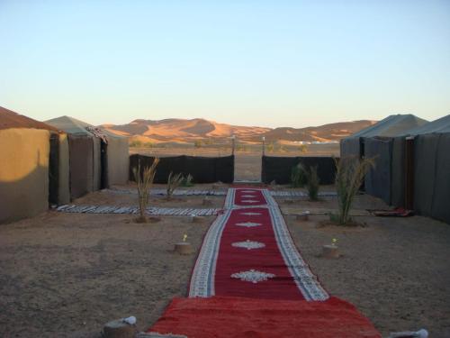 un tappeto rosso in mezzo al deserto di Honeymoon Luxury Glamping ad Adrouine