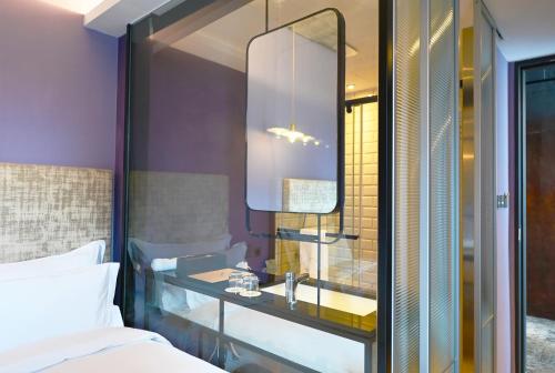1 dormitorio con lavabo y espejo en CHECK inn HIVE, en Luodong