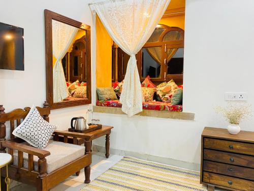 Cette chambre comprend deux miroirs, une chaise et une commode. dans l'établissement Jasmer Haveli, à Jaisalmer