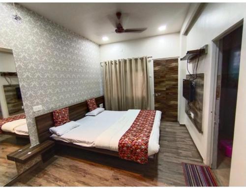 a bedroom with a bed and a television in it at Geeta Lodge, Solapur in Solapur