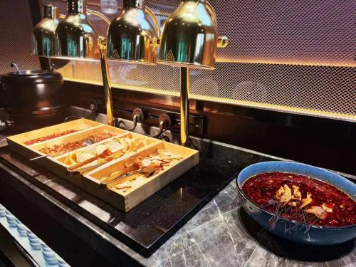 a counter with a tray of food and a bowl of sauce at Kunming Dianchi Mideel International Apartment - South Asian Style Fuhai Metro in Kunming