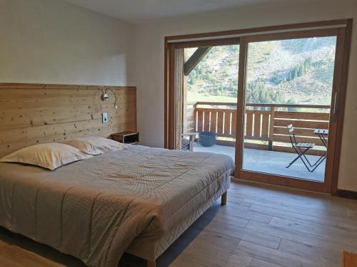 a bedroom with a large bed and a large window at Hôtel du Lac des Confins in La Clusaz