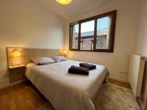 sypialnia z dużym łóżkiem z dwoma ręcznikami w obiekcie Appartement Porte de Paris / Stade de France w mieście Saint-Denis