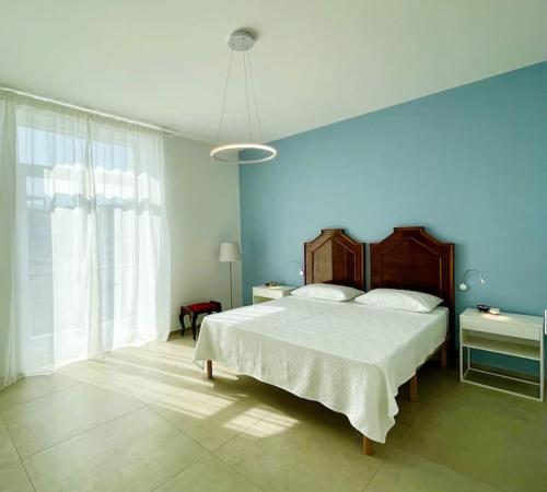 a bedroom with a large bed and a blue wall at L'Ancora appartamenti 3 in Giovinazzo