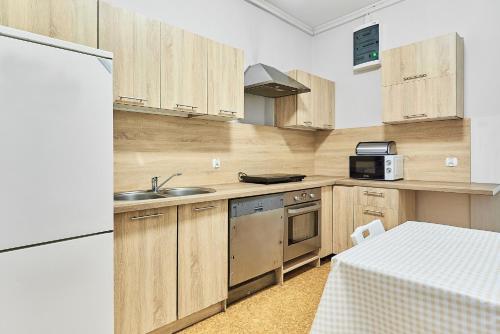 uma cozinha com armários de madeira e um lavatório em Viola em Police