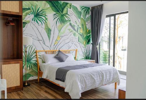 a bedroom with a bed with a tropical wallpaper at Villa Sapphire9 Aria Vungtau in Xa Thang Nhut