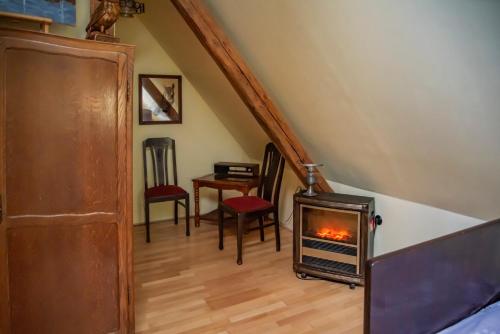 a living room with a fireplace and a staircase at Dawny Dom in Płoty