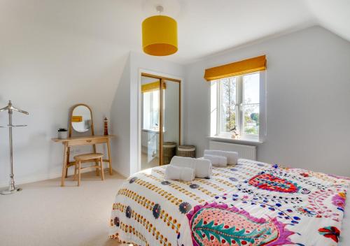 a bedroom with a large bed with a colorful blanket at The Salty Dog in Aldeburgh