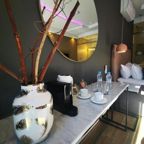 a table with a vase with drinks and a mirror at Hill Valley Asilah - Luxury Living & Boutique Hotel in Asilah