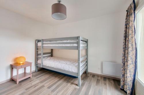 une chambre avec un lit superposé et une table dans l'établissement Grande maison pour 10 avec piscine, à Avrillé