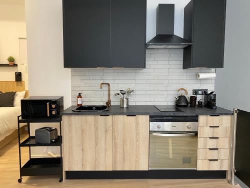 a kitchen with black cabinets and a counter top at Auditorio/Bernabéu Apartment2 in Madrid