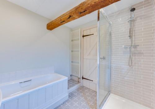 a bathroom with a tub and a glass shower stall at 1 Church Farm in Blythburgh