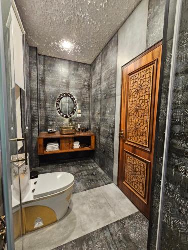 a bathroom with a tub and a toilet and a mirror at Qiz Galasi Hotel Baku in Baku