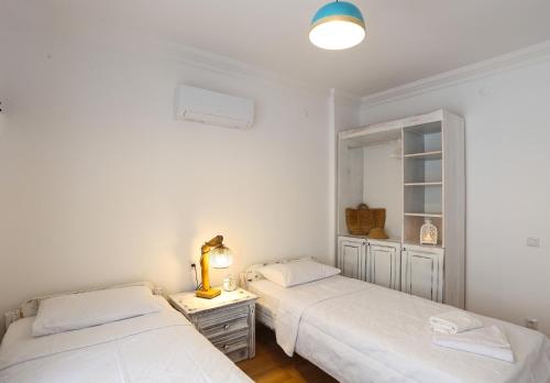 2 Betten in einem Zimmer mit weißen Wänden in der Unterkunft Destiny Apart in Kaş